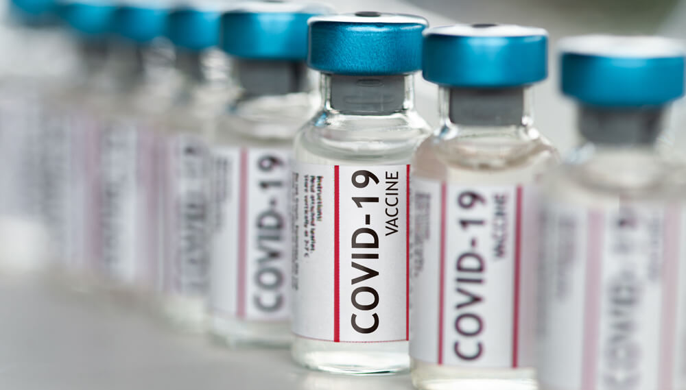 Glass bottles with labels that read "COVID-19 vaccine."