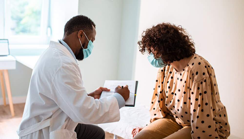 Doctor and patient speaking in an exam room.