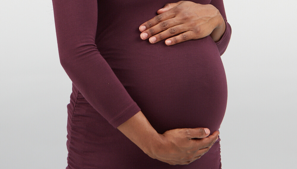 Pregnant woman holding belly.