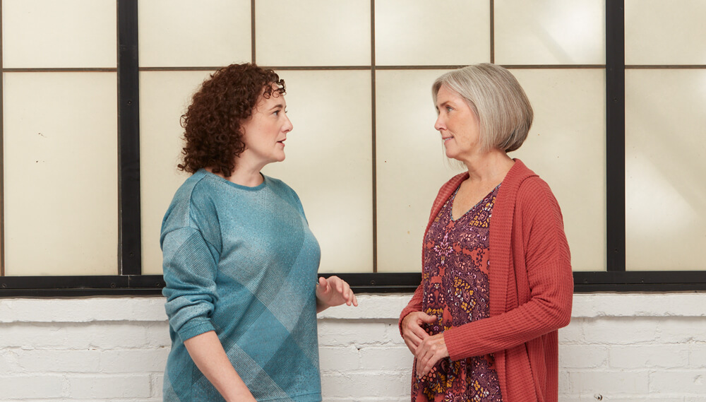 Two middle-aged women talking.