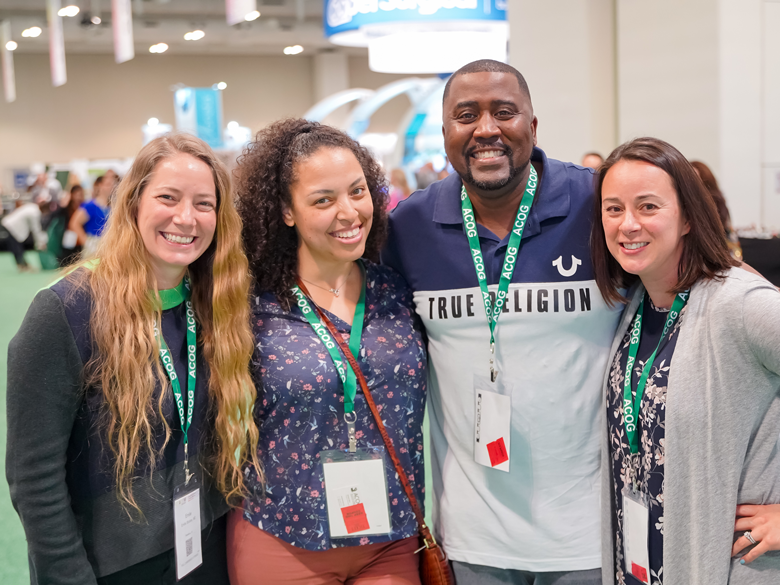 Four attendees at ACOG's Annual Clinical & Scientific Meeting smile at the camera.